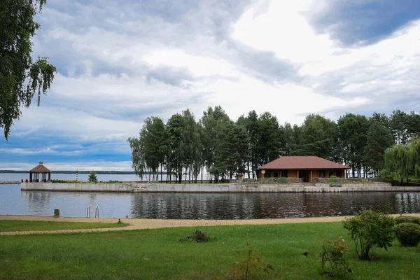 Near the reservoir there is a gazebo and a guest house, as well as a swimming pool. The sky is overcast
