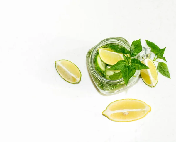 Sağlık hizmeti, fitness, sağlıklı beslenme diyeti konsepti. Taze soğuk limon salatalığı naneli su, kokteyl, detoks içeceği, cam kavanozda limonata. Açık kopya alanı üst görünüm düz arkaplan