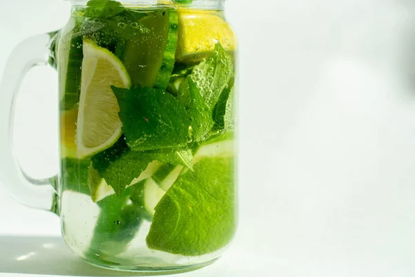 Sağlık, fitness, sağlıklı gıda konsepti. Taze taze limon, naneli su, kokteyl, detoks içeceği, cam kavanozda limonata. Işık alanı, yan görünüm, beyaz arkaplan, izole et.