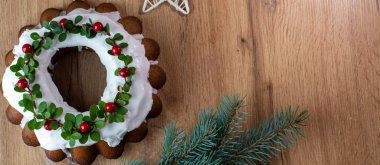 Noel Stollen: Kızılcık ve dallarla süslenmiş şenlikli bir pasta. Noel dekoru masada. Tebrik kartı, pankart ve bayram tebrikleri kavramı.