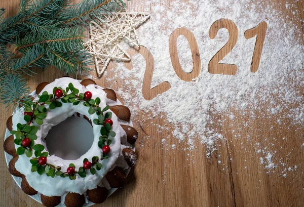 Noel Stollen: Kızılcık ve dallarla süslenmiş şenlikli bir pasta. Noel dekoru masada. Tebrik kartı, pankart ve bayram tebrikleri kavramı. Yeni yıl 2021
