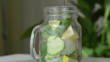 Sağlık hizmeti, fitness, sağlıklı beslenme diyeti konsepti. Taze soğuk limon salatalığı, nane şekeri, kokteyl, detoks içeceği, cam kavanozda limonata..