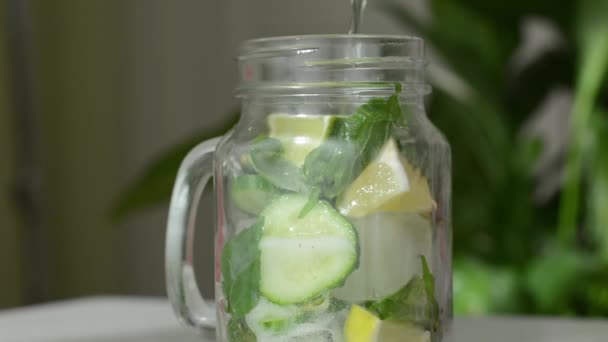 Soins de santé, fitness, alimentation saine concept de régime. Fraîche fraîche citron concombre menthe eau infusée, cocktail, boisson de désintoxication, limonade dans un pot en verre. — Video