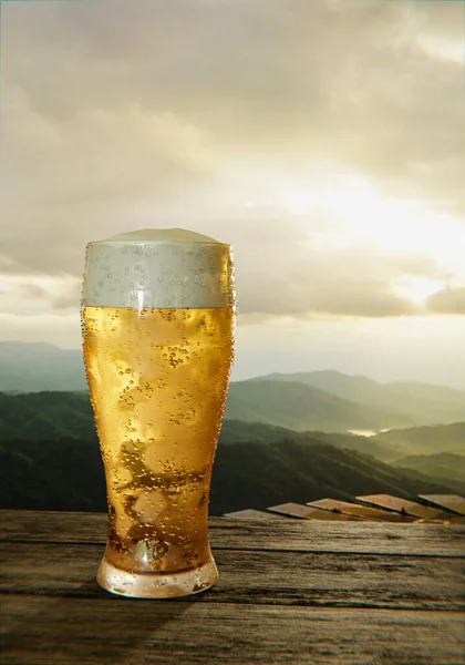 ガラスの口の中で冷たいビールと泡でビールのガラスをクリアし 水滴は端に付着します プランクロードや木材の表面と朝の太陽の下で山の風景です 3Dレンダリング — ストック写真