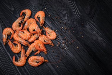 Siyah arka planda biberli haşlanmış karides.