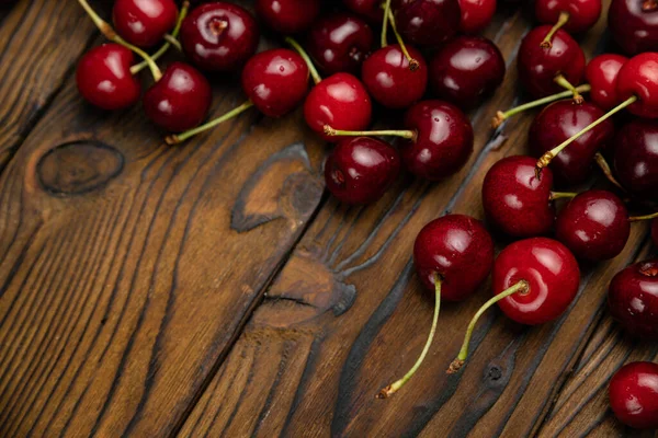 Olgun, kırmızı, kahverengi ahşap arka planda çiftlik kirazları