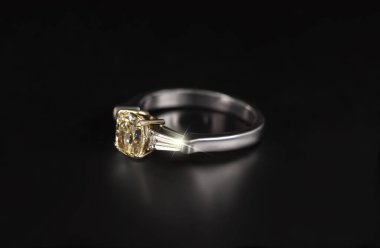 Siyah arka planda izole edilmiş elmas değerli taşlı altın bir yüzük.