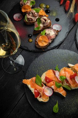 İtalyan bruschetaları, yumuşak peynirli ve somonlu, etli ve baharatlı ve domatesli vejetaryen.