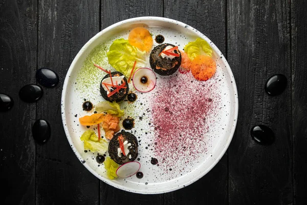 Somon ve peynirle doldurulmuş fırında patates. En iyi restoranda beyaz bir tabakta sebzelerle