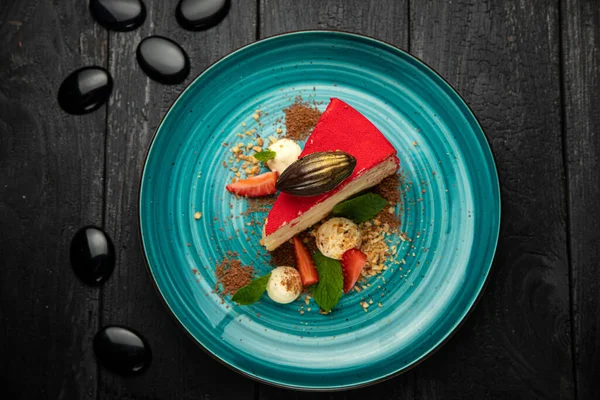 Yuvarlak tabakta çilekli Napolyon keki ve dondurma.