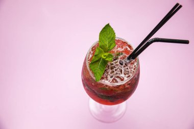 Çilekli mojito, ahududu ve naneli. Pembe masanın üzerinde..