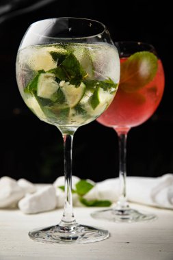 Çeşitli soğuk kokteyller - mojito ve ahududu. Tahta, beyaz bir masada