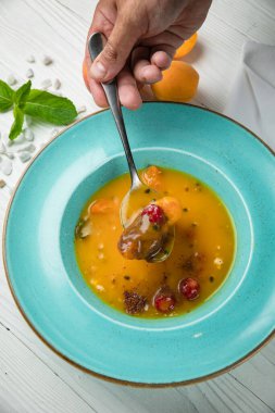 Soğuk mango-tutkulu meyve çorbası. Beyaz ahşap bir masada