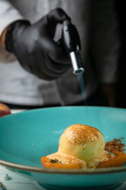 Karamelli, meyveli sütlü dondurma. Beyaz ahşap bir masada.