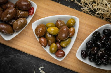 Koyu bir betonda farklı türde zeytin.