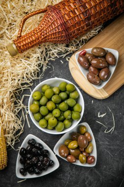 Koyu bir betonda farklı türde zeytin.