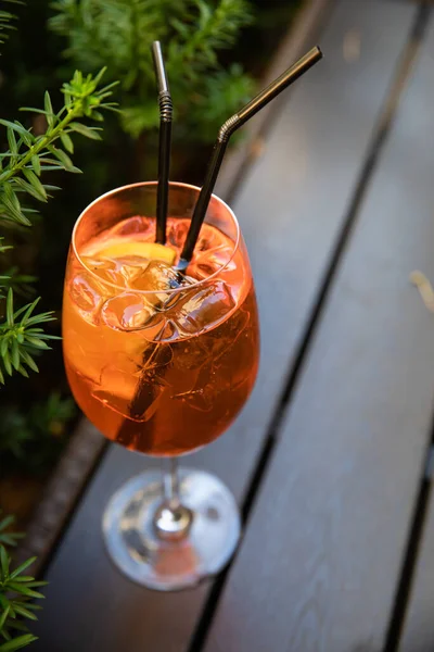 オレンジ色のアルコール飲料氷とメガネのアペロール 裏庭のテーブルの上に立つ — ストック写真