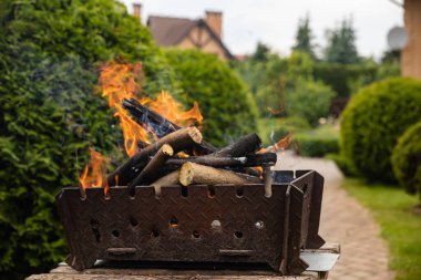 Arka bahçedeki barbeküde yanan bir ateş..