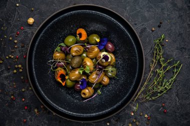 Koyu bir betonda farklı türde zeytin.