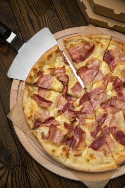 Pizza, stokta. Kahverengi ahşap bir masada.