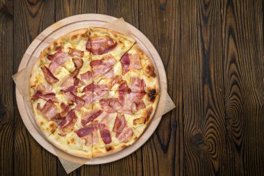 Pizza, stokta. Kahverengi ahşap bir masada.