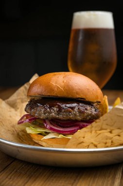 Bir Amerikan restoranının menüsünden hamburger. Tahta bir masada.