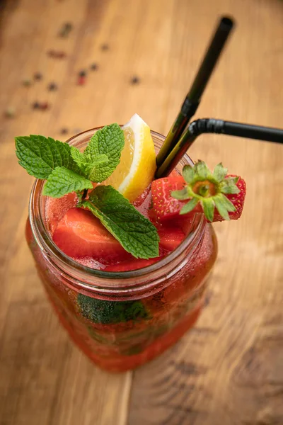 Lemonade with strawberries, lemon and mint from the menu of an American restaurant. On a wooden table
