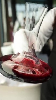 Şeffaf bir sürahide kırmızı şarap. Yavaş çekim videosu, yakın çekim. Barmen şarap hazırlar..