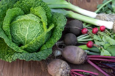 Ahşap bir arka planda Savoy lahanası ve diğer sebzeler. Sonbahar hasadı. Sebze bileşimi.