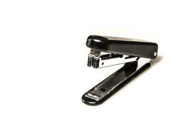 Plastik ve çelik zımba, siyah ve gümüş, beyaz bir yüzeye yerleştirilmiş.