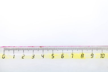 10 cm boyunda şeffaf bir cetvel, beyaz arkaplan üzerinde yatay olarak konumlandırılmış.