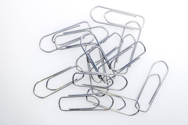 some overlapping metal staples, forming a small pile on a white surface