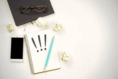 Yeni fikirler. Üç ünlem işaretli defter, kağıt toplar, akıllı telefon, dizüstü bilgisayar, kalem. Boşluğu kopyala