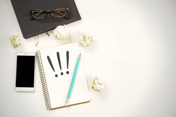 new ideas concept. notebook with three exclamation marks, paper balls, smartphone, laptop, pencil. copy space