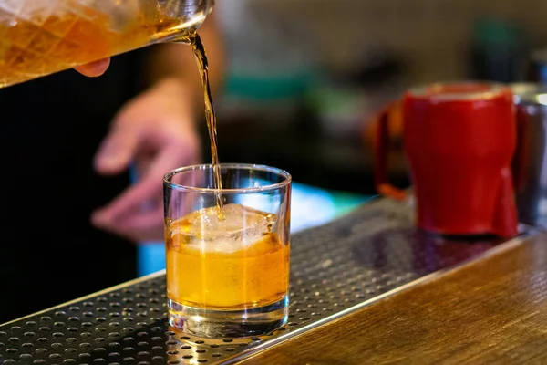 Barman Dělá Koktejl Nalévá Sklenice Pomerančového Černocha Červená Konvice Rozostřené — Stock fotografie