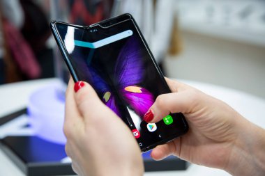 Moskova, Rusya - Ekim 04, 2019: Samsung Galaxy Katlaması 'nın esnek bir görüntüsü olan yeni bir sancak gemisi akıllı telefonu tutan kadın elleri. Kapat. arkaplan bulanık.