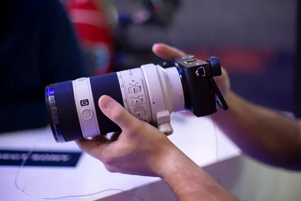 Moskau, Russland - 04. Oktober 2019: Männer halten neue Kamera Sony Alpha a7 iii 3 mit Objektiv Sony 70-200 3,28-4,92. Weicher Fokus, Seitenansicht — Stockfoto