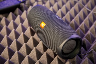 Moskova, Rusya - Ekim 04, 2019: siyah taşınabilir bluetooth su geçirmez müzik hoparlörü JBL Charge 4, gürültü azaltma kapağına dayanır. yumuşak odak, bulanık arkaplan.