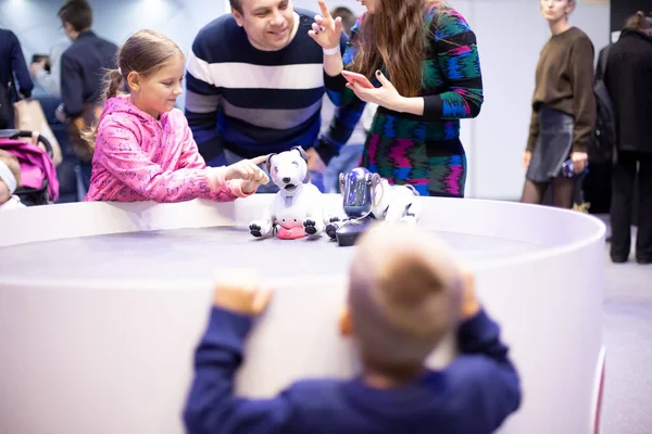 Moskova, Rusya - Ekim 04, 2019: Çocuk kız, Sony Pet robot teknolojisi tarafından tasarlanan ve üretilen Aibo Robotik evcil hayvanlarla oynar. Ön taraf bulanık, yumuşak odaklı.