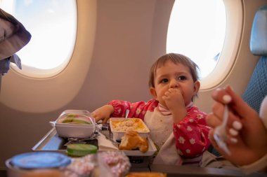 Şirin bebek uçak yolcusu özel bebek yiyor. Yemeği kirletiyor.