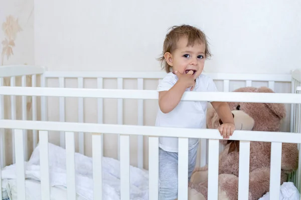 Карантинний концепт. безпека є відносною. маленький милий малюк стоїть в ліжечку і дивиться на камеру — стокове фото