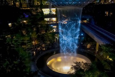 SINGAPORE - 3 Mart 2020 'de Changi Havaalanı, Singapur' un dördüncü terminalindeki alışveriş merkezinde bir şelale. Suda ışık gösterisi
