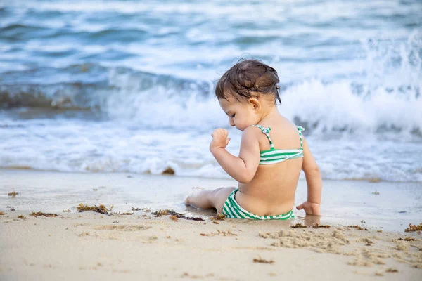 Dziewczyna siedzi w oceanie Breaking Waves On the Sand Beach — Zdjęcie stockowe