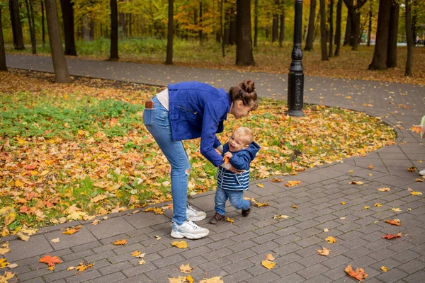 Mom plays with the baby Toddler in autumn park — Stock Photo, Image