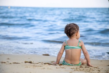 Okyanusta oturan Kum Sahilinde Dalgaları kıran Kız