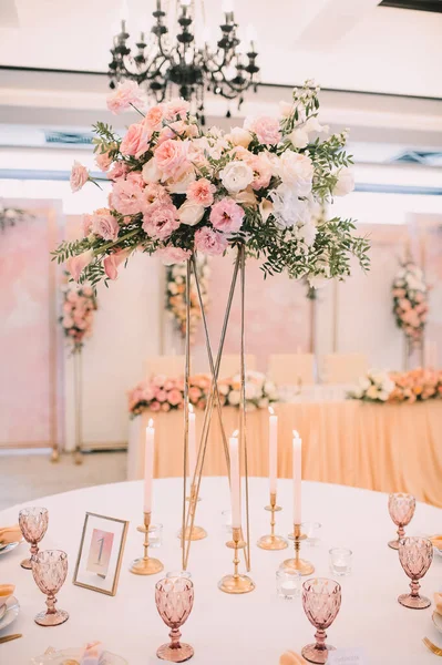 餐桌布置 白色盘子 金色餐具 有金戒指的桃色餐巾 桃红色的花的排列 金烛台上的高锥形蜡烛 — 图库照片