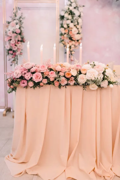 餐桌布置 桌上有一块粉红色的桌布 主席团 新婚夫妇的餐桌 桌子上有一块桌布 桃红色色泽中的花朵排列 高大的蜡烛 — 图库照片