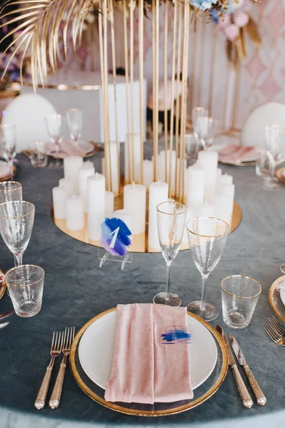 有蓝色天鹅绒桌布的宴席 盘子和餐具 男仆的石灰玻璃杯 粉红天鹅绒餐巾 高立柱 由玫瑰花 水仙花 金叶组成 — 图库照片