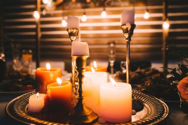 Düğün, masanın üzerindeki dekor, mumlar yanıyor, bir buket çiçek. Kırsal ahşap arka plan...