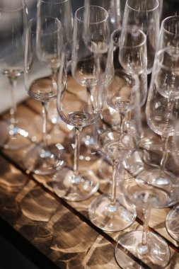 Bir sürü boş şampanya ya da şarap bardağı güneşte parlıyor. Resepsiyon ya da tatil için hazırlık, alkollü içecekler için konteynır. Restoran, yemek servisi, servis.
